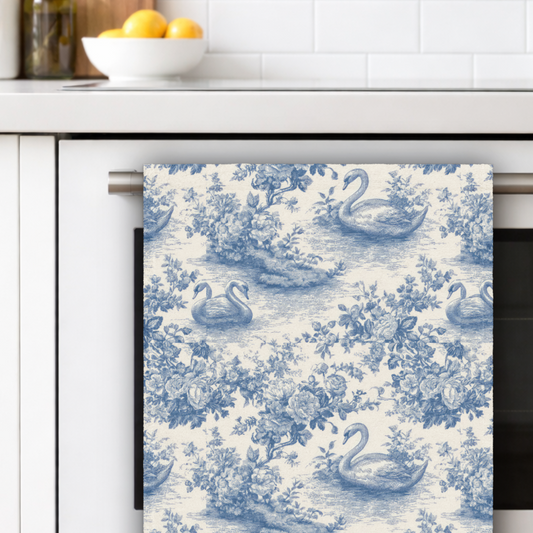 Decorative towel with swan pattern hanging on a kitchen towel rack.