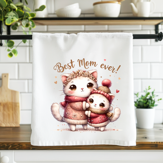 Towel with cartoon cats and 'Best Mom ever!' text in a kitchen setting