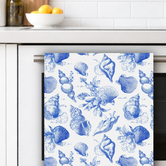Towel with blue shell pattern hanging on a kitchen rack.