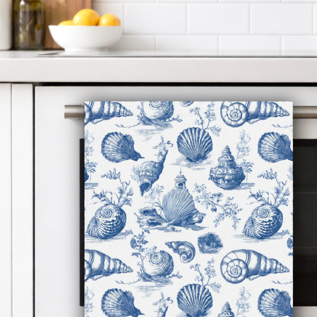 Kitchen towel with blue shell pattern hanging on a cabinet handle.