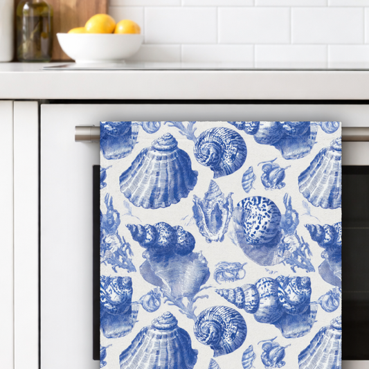 Kitchen towel with blue shell pattern hanging on a kitchen rack.