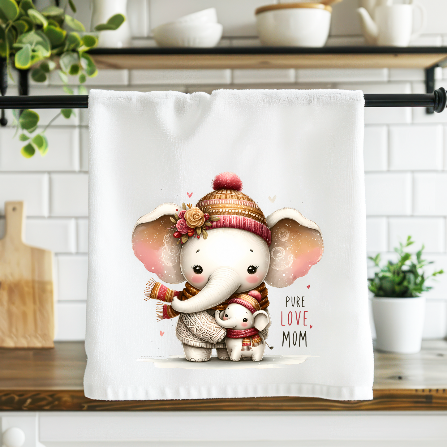 Kitchen towel with an elephant design hanging on a rack in a kitchen.