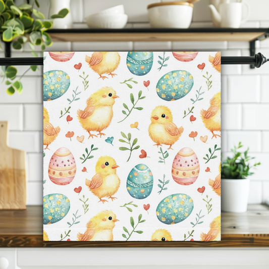Towel with Easter design featuring chicks and eggs on a kitchen towel rack.