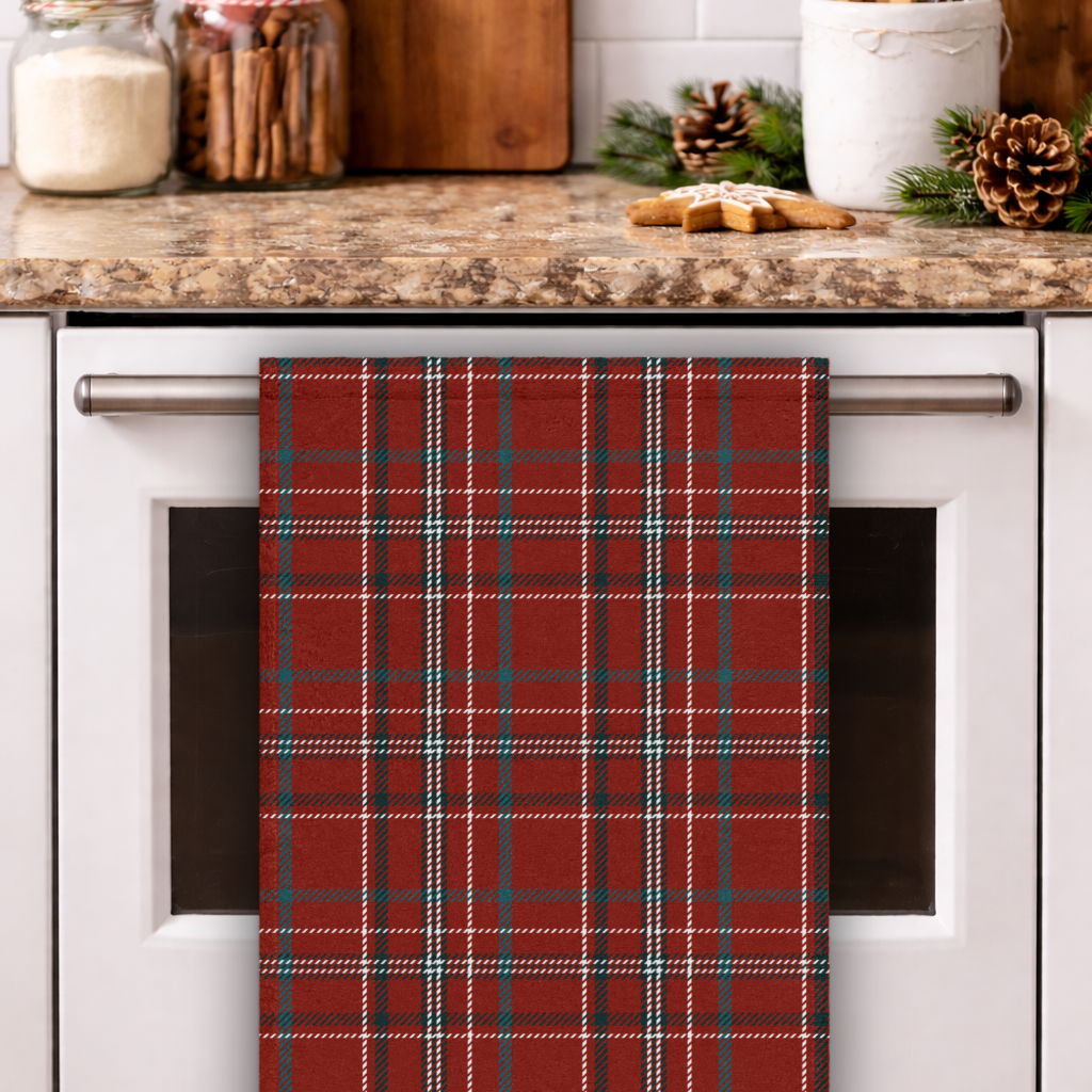 Red plaid towel hanging on a kitchen cabinet handle with a festive kitchen setting.