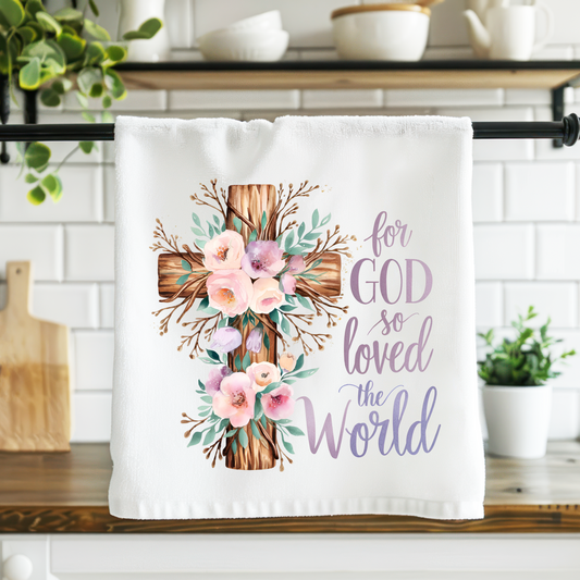 Floral cross design towel with 'For God So Loved the World' text on a kitchen towel rack.