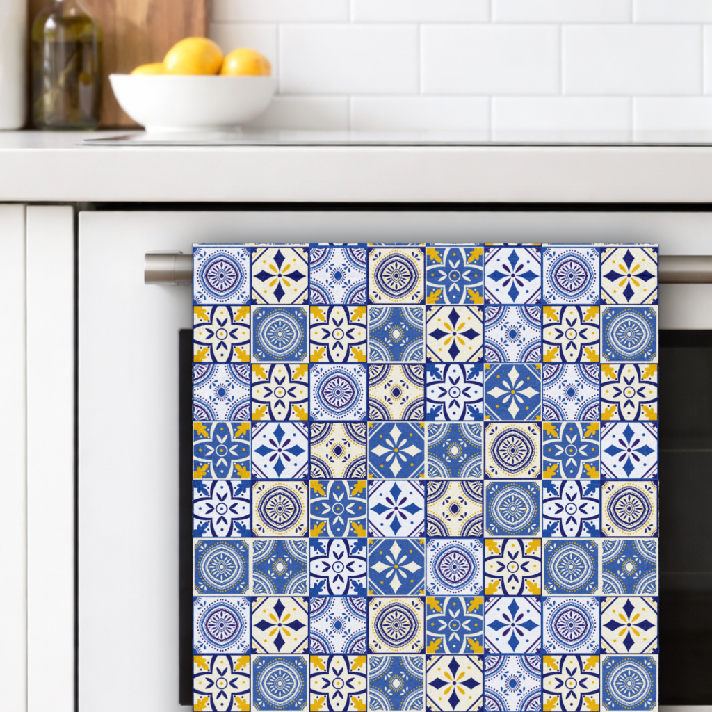 Decorative kitchen towel with blue and white pattern hanging on a cabinet handle.