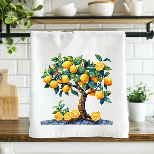 Kitchen towel with an orange tree design hanging on a rack in a kitchen.